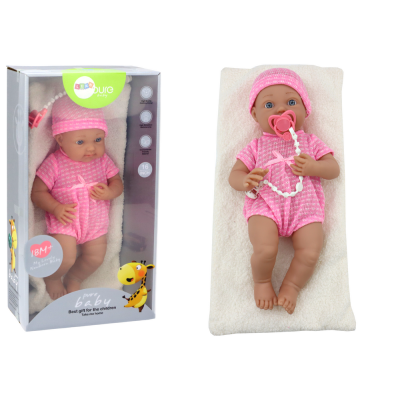 Baby doll in pink clothes, hat, pacifier, and blanket